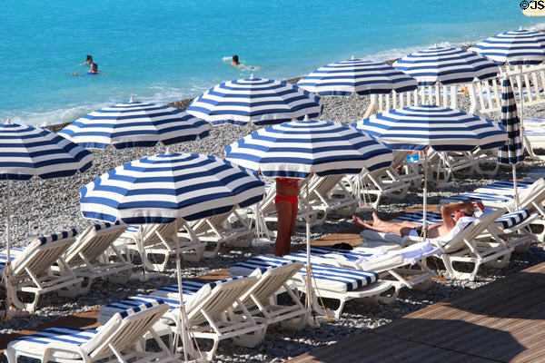 Striped umbrellas on beach along Promenade des Anglais. Nice, France.