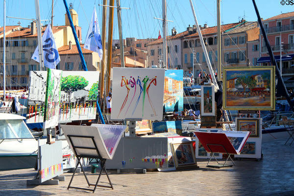 Display of artist's work along harbor. St Tropez, France.