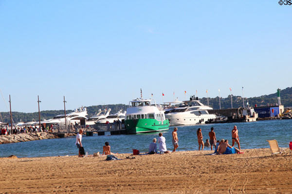 Tourists enjoying beach along harbor. Sainte-Maxime, France.