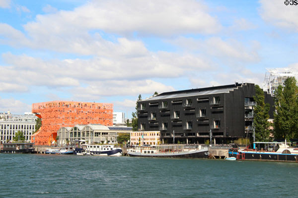 "Communiquez" headquarters (2007) (45 quai Rambaud) with orange Les Salins offices (2011) beyond along Saône River in Confluence district. Lyon, France. Architect: J.-M. Wilmotte / K. de Koning.