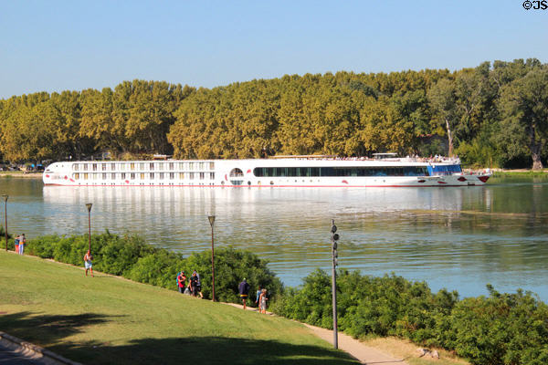 Tourist cruise boat on Rhone River seen from bridge of Avignon. Avignon, France.