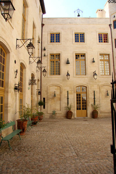 Courtyard of Palais du Roure hung with lamps & bells. Avignon, France.