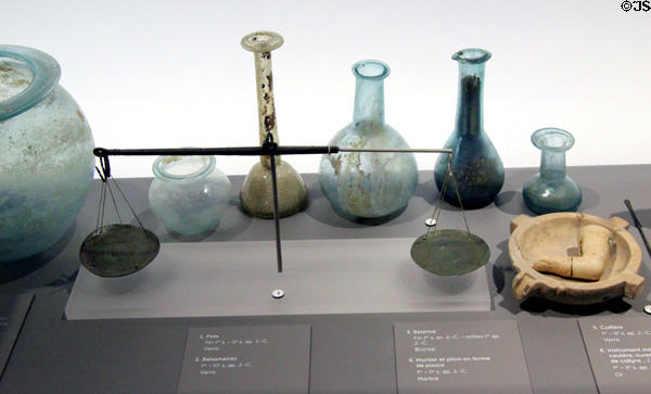 Collection of Roman glass bottles & bronze balance (c1st-2ndC) at Musée de la Romanité. Nimes, France.