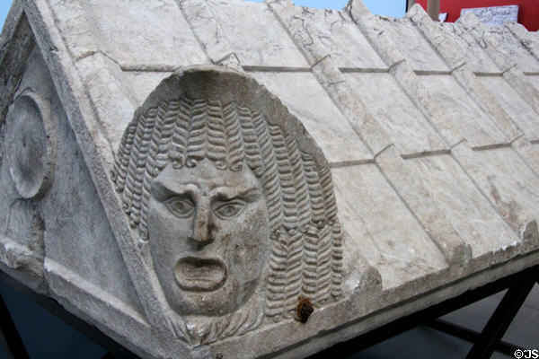 Roman-era marble sarcophagus cover with corner theatrical tragedy mask (early 3rdC) at Arles Antiquities Museum. Arles, France.