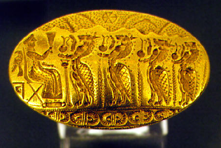 Part of Tiryns Treasure from 15 to 11th century BC with gold signet ring (left) depicting lion-headed genii in procession to deity raising chalice and a gold ring depicting man leading woman to anchored ship from National Archeological Museum, Athens. Greece.