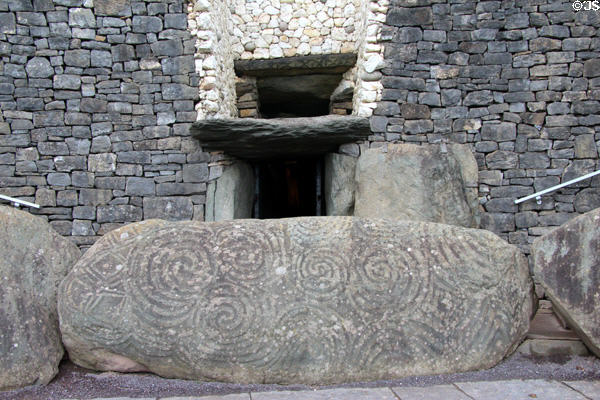 Passage tomb entrance guarded by Megalithic-carved swirl at Newgrange. Ireland.