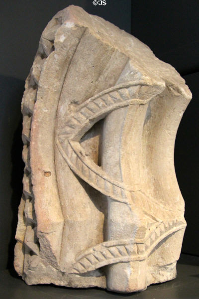 Stone ribbons bind arch carving (13thC) at Old Mellifont Abbey museum. Ireland.