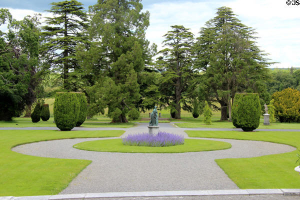 Statue with flower in garden at Emo Court. Ireland.