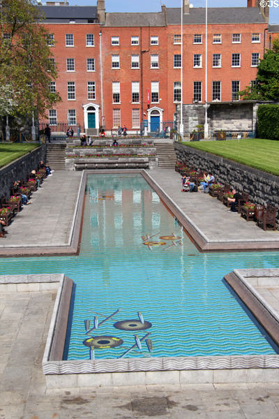 Cruciform pool of Garden of Remembrance with symbolic mosaic of discarded weapons on bottom of flowing river. Dublin, Ireland.