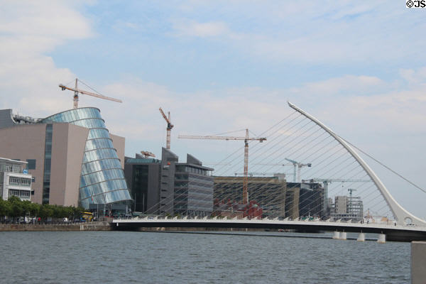 Dublin Convention Center with leaning glass cylinder beside Samuel Beckett Bridge over River Liffey. Dublin, Ireland.
