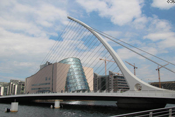 Dublin Convention Center (2010) framed by Samuel Beckett Bridge over River Liffey. Dublin, Ireland. Architect: Kevin Roche.