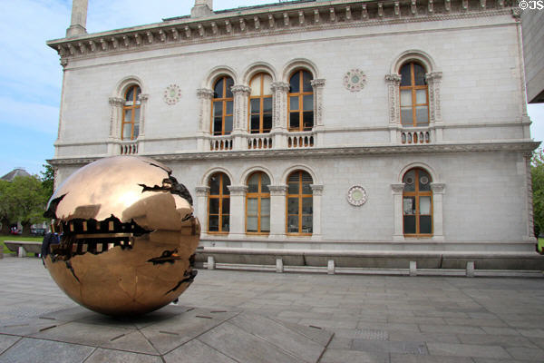 Sphere Within Sphere sculpture (1982) by Arnaldo Pomodoro & Museum Building at Trinity College. Dublin, Ireland.