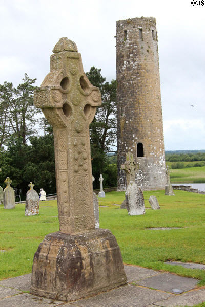 O'Rourke's Round tower with replica of South Cross at Clonmacnoise. Ireland.