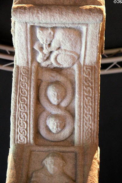 Carved cat & two faces on figure 8 on edge of ring of Cross of Scriptures at Clonmacnoise museum. Ireland.