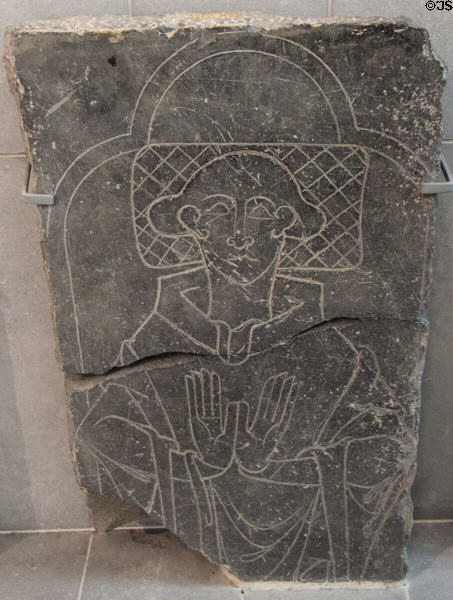 Tomb slab (1200s) engraved with figure of praying priest at Medieval Mile Museum. Kilkenny, Ireland.