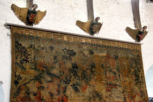 Carved figures above tapestry hanging in Great Hall at Bunratty Castle. County Clare, Ireland.