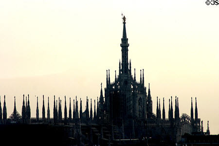 Duomo dome & spires in against morning sun. Milan, Italy.
