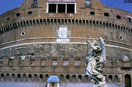 One of the Bernini angels (1667-9) on Sant'Angelo bridge with details of facade of Castel Sant'Angelo behind. Rome, Italy.