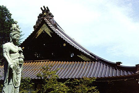 Statue and sloping roof of the Daishoin Temple, Miya-jima. Japan.