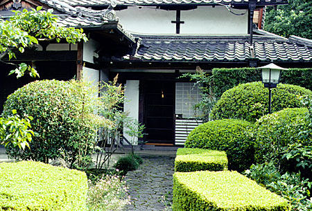 Hedges line a walkway to a house in Nara. Japan.