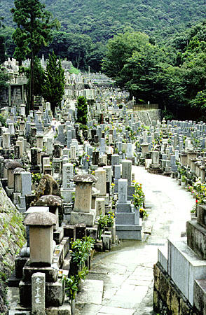 Numerous stone markers flank a path through a cemetery in Kyoto. Japan.