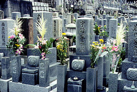 Flowers, candles and incense as offerings to the deceased at a cemetery in Kyoto. Japan.