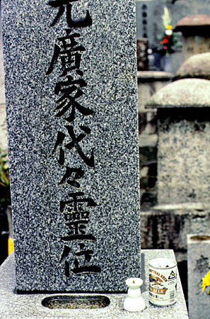 Offering of beer sits on a stone marker in a Kyoto cemetery. Japan.