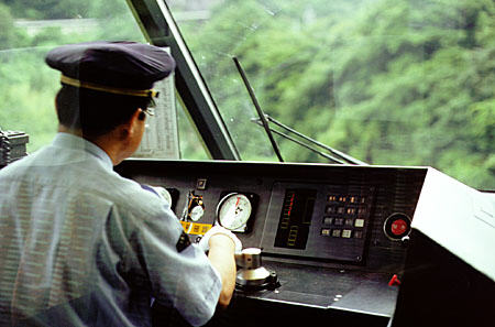 Driver in the cab of a train leaving Takayama. Japan.
