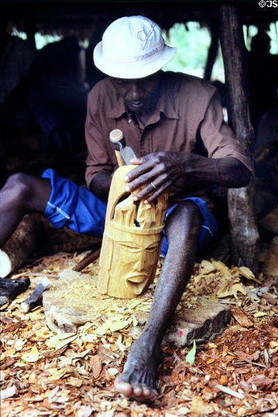 Carver working on a wooden sculpture in Malindi market. Kenya.