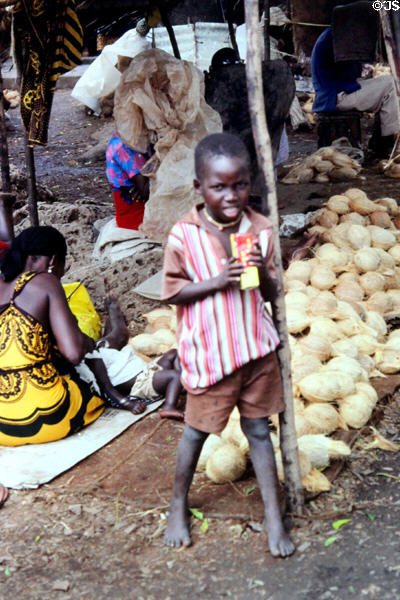 Child amongst vendors stalls of Malindi market. Kenya.