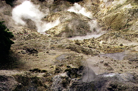 The steaming volcanic caldera of Sulphur Springs Park, traversed by a road creating a unique drive-in volcano. St Lucia.