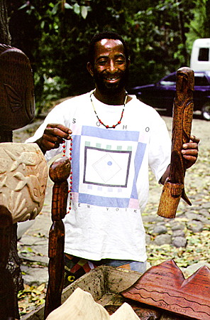 Artisan Sylvester Modeste, one of several offering their carvings and necklaces to visitors. St Lucia.
