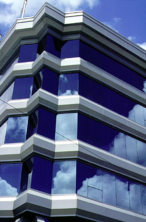 Windows of the St Lucia Development Bank reflect the Castries sky. St Lucia.