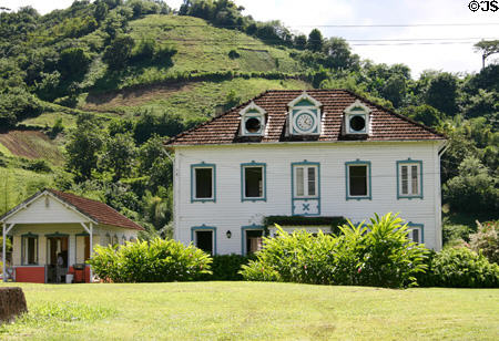 Maison du Géreur with clock & blue trim above St Pierre. Martinique.