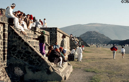People sunning on ancient walls at Teotihuacán with Pyramid of Moon beyond. Mexico.
