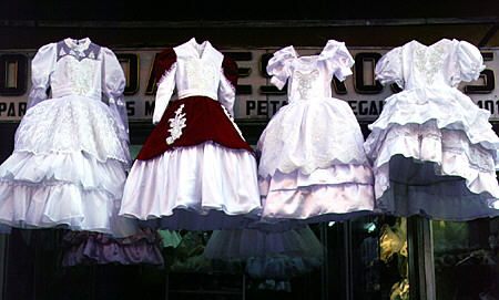 Confirmation dresses hang in front of a store in Puebla. Mexico.