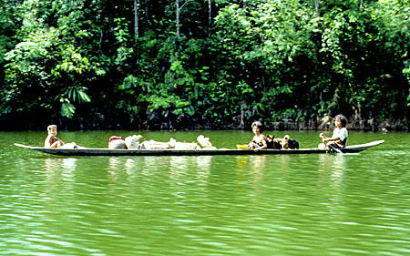 Family in a canoe passed on Eng Kari river in Sarawak. Malaysia.