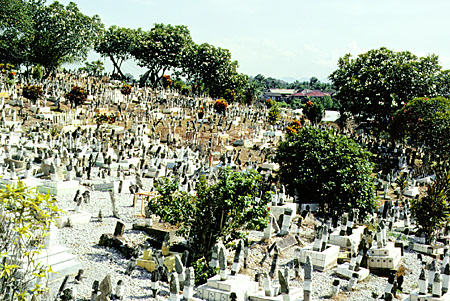 Moslem cemetery in Kuching with square tombstones for men, round tombstones for women, and color wrapping for royalty. Malaysia.