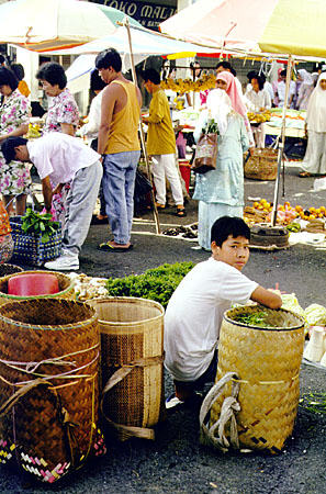 Farmers bring produce to market using baskets on their backs in Kuching. Malaysia.