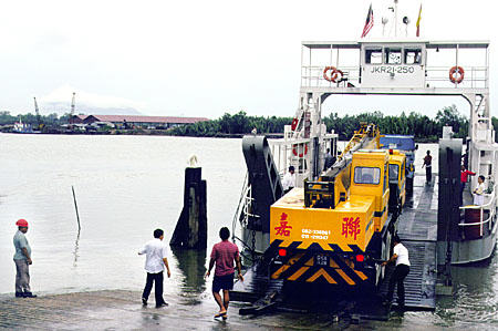 Crane being loaded onto a ferry on road to Bako National Park in Sarawak. Malaysia.