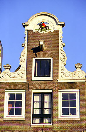 Gabel of building near Nieuwmarkt with red-caped horseman. Amsterdam, Netherlands.