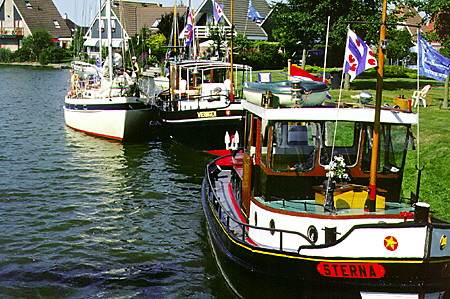 Boats moored along the canal. Sloten, Netherlands.