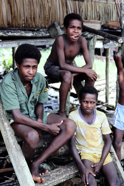 Boys sitting on the steps of a house in Mendam. Papua New Guinea.