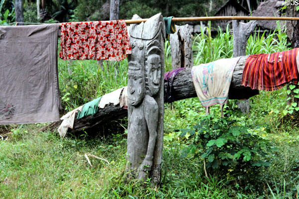 Carved post supports a pole full of laundry in Timbunke. Papua New Guinea.