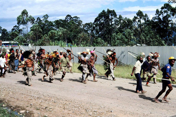 Armed with spears villagers run down road to combat. Papua New Guinea.