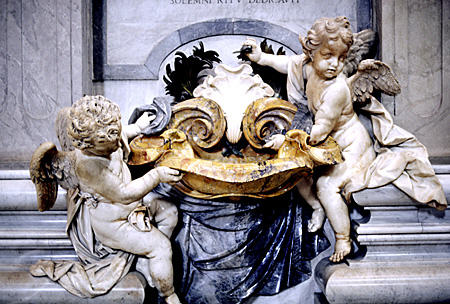 Baroque cherubs hold holy water font within St Peter's Church, Vatican. Vatican City.