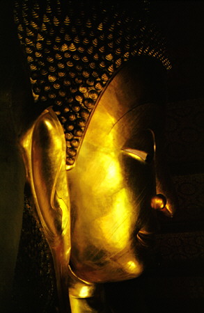 Close up of the face of the 40m-long reclining Buddha in Wat Pho, Bangkok. Thailand.