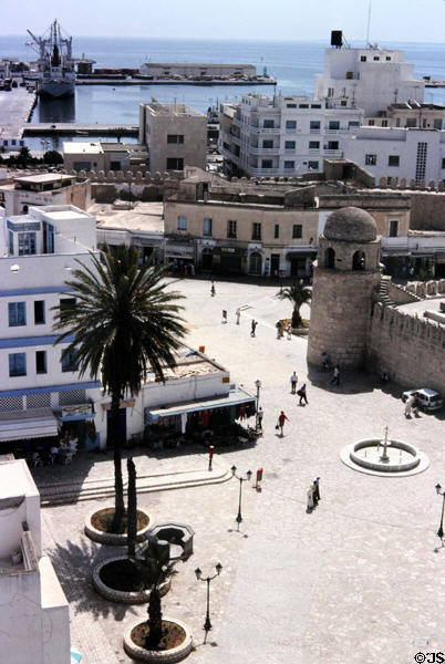 Rue Al Madina Almounawara pedestrian street with corner tower of Great Mosque & port beyond. Sousse, Tunisia.