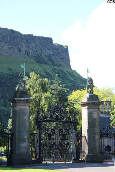 Holyrood Palace gates seen against Salisbury Crags volcanic rock formation of Arthur's Seat. Edinburgh, Scotland.