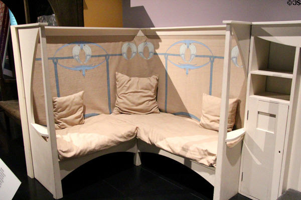 White painted settle (1900) with reproduction cushions & hanging by Charles Rennie Mackintosh at National Museum of Scotland. Edinburgh, Scotland.